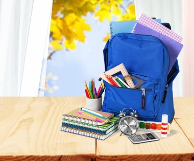 Ahşap masa üzerinde okul sırt çantası ile ileti örneği