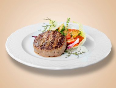 beyaz tabakta biftek ve salata 