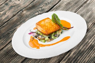 Beyaz tabakta sebzeli ızgara somon balık