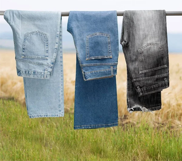 Trzy Jeansy Wiszące Nad Trawą — Zdjęcie stockowe