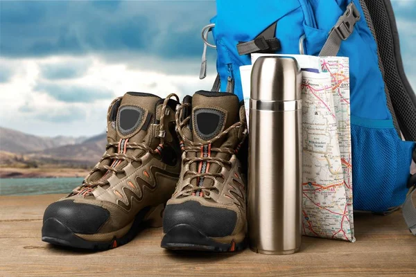 Hiking boots, backpack and map. Travel concept