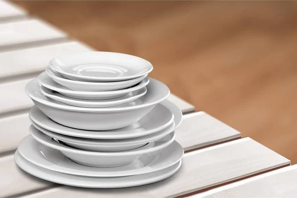 Clean plates and cups on wooden table