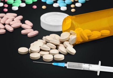  different pills and syringe on  background.