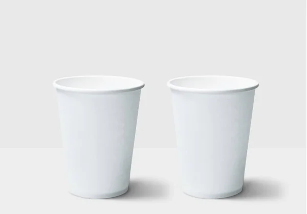 白いテーブルの上の2つのプラスチックカップ — ストック写真