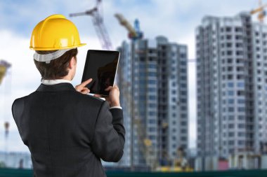 tablet pc bilgisayar ile hardhat geri duran mühendis 