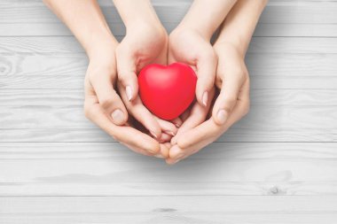 Bir adam ve bir kadın kırmızı kalp taşıyor.