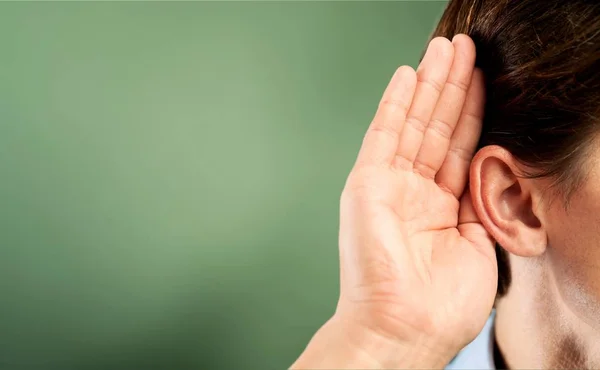 Businessman holds his hand near ear — Stock Photo, Image