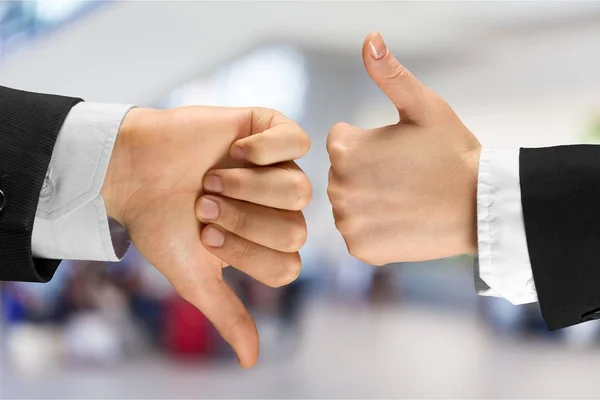 hands of businenessmen showing thumbs up and down