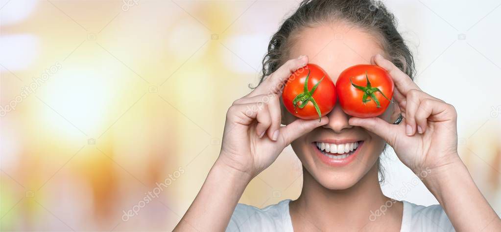 happy woman covering eyes with tomatoes 