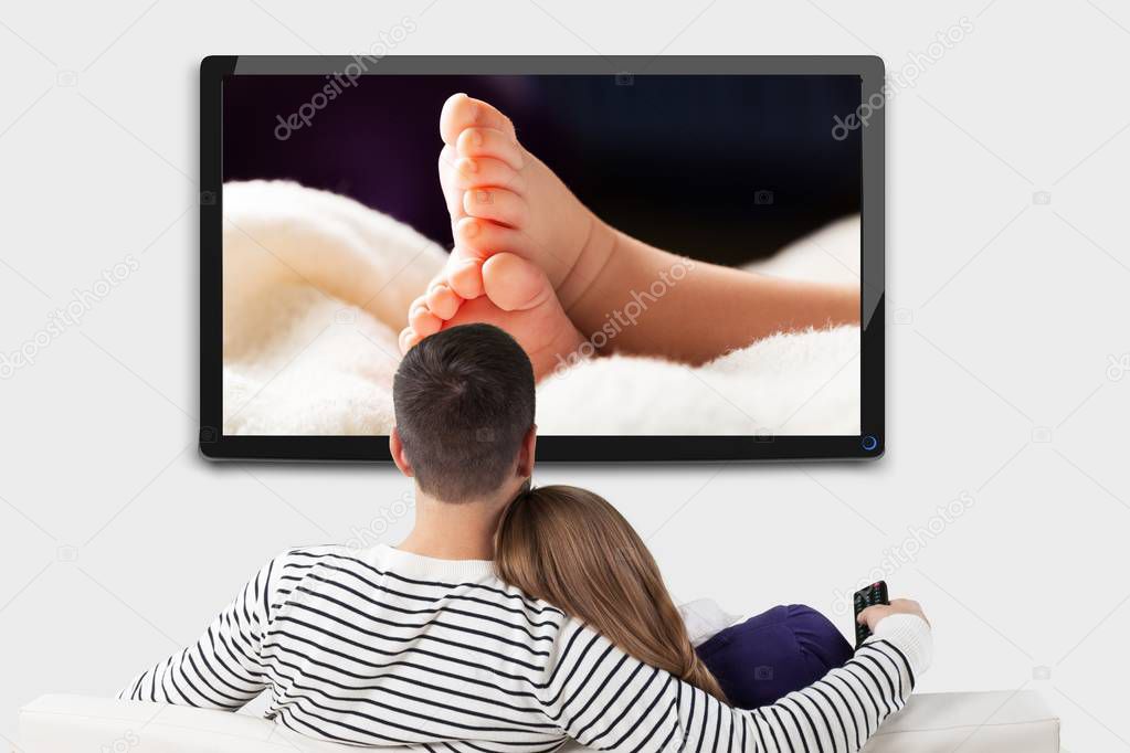 Loving couple watching photos on tv 