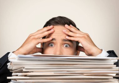 Kağıt arka plan üzerinde yığın yakınındaki işadamı  