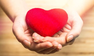 Ellerinde arka plan üzerinde kırmızı kalp 