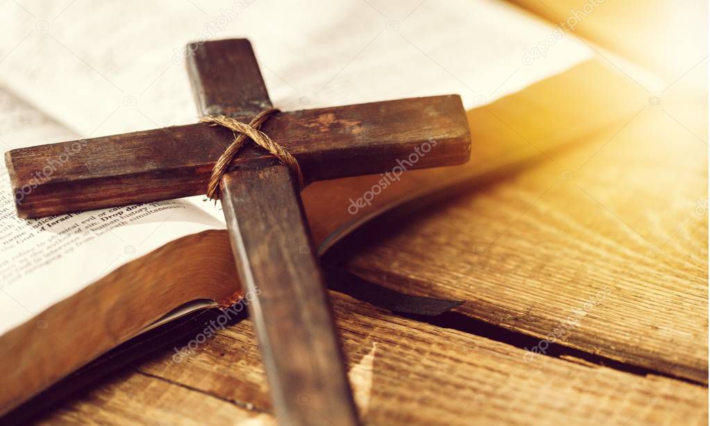 Cross on bible, religious concept, wooden table