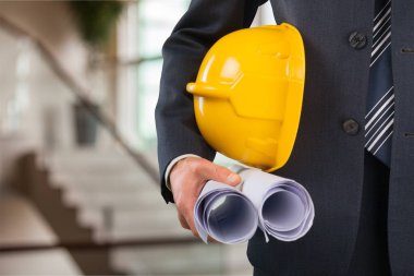 sarı kask ve planları tutan işadamı 