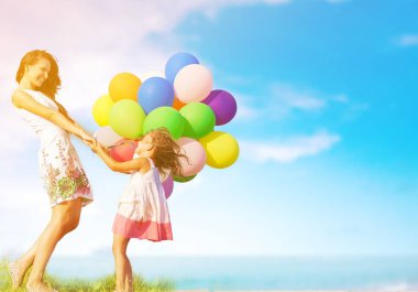 Anne ile kızı holding renkli balonlar