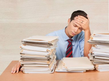 Office belgeleri yığını ile yorgun işadamı 