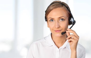 Müşteri hizmetleri temsilcisi, kulaklıkla konuşan genç gülümseyen kadın