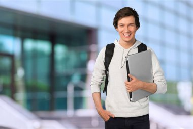 Dizüstü bilgisayar ile gülümseyen öğrenci adam 