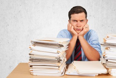 Office belgeleri yığını ile yorgun işadamı 