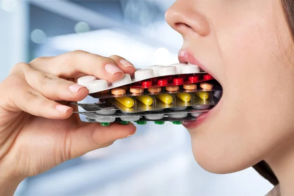 Chica comiendo un montón de pastillas — Foto de Stock