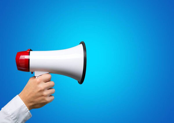 portrait of young woman shouting through megaphone