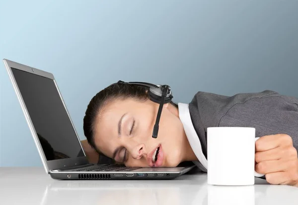 tired young woman in headset fell asleep on laptop