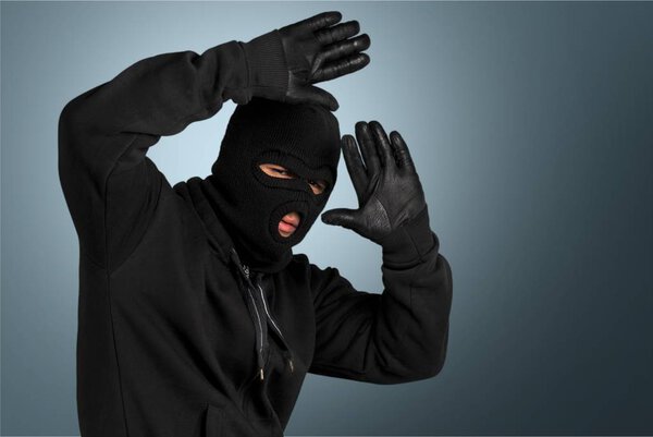 Грабитель в черной маске и перчатках
