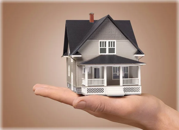 Hand holding house model isolated on  background