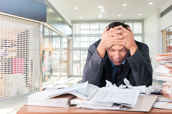 書類の山が付いているオフィスで疲れたビジネスマン — ストック写真