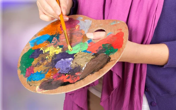 Artist paints a picture of oil paint brush, close-up view