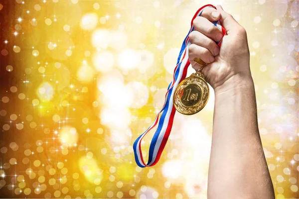 man\'s hand with gold medal