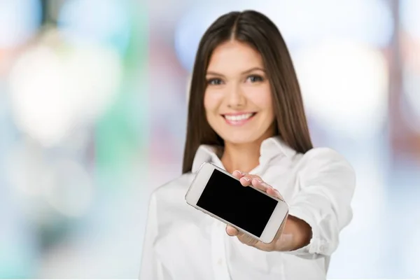 微笑的年轻女子与智能手机在她的手中 — 图库照片