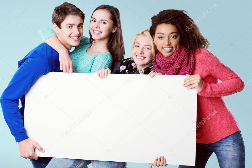 happy young friends with blank board