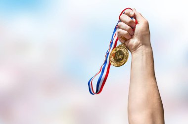 Adamın eli altın madalyayı tutuyor. 