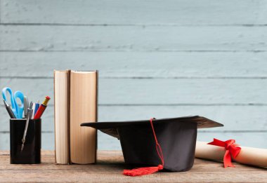 Mezuniyet şapkası, kitaplar ve diploma. 