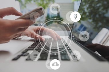 Telefon tutarak ve arka plan üzerinde dizüstü kullanarak eller 