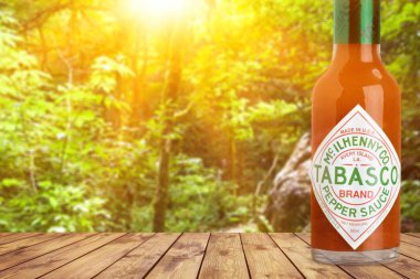 Ahşap masada bir şişe acı sos. 