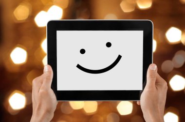 Gülümseme sembollü dijital tablet kullanan bir kadının yakın plan görüntüsü