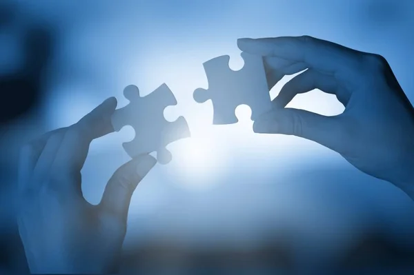 Hands with pieces of puzzle — Stock Photo, Image