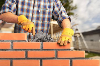 Masonry work, bricklayer constructing brickwall clipart