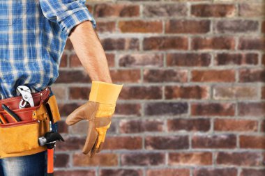 Tuğla duvarla çalışan bir işçi