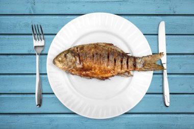 Ahşap masada tabak üzerinde kızarmış balık