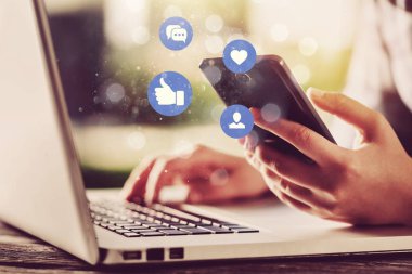 Arka planda telefonu ve bilgisayarı olan iş adamı 