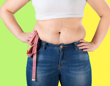 Koca göbekli genç bir kadın elinde mezura tutuyor. 