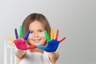 küçük kız boyalı gösterilen arka plan üzerinde eller  