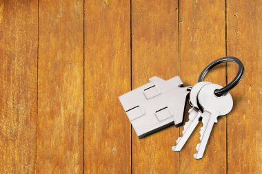 Evin anahtarları ahşap arka planda. en üstteki görünüm