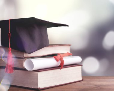 Mezuniyet şapkası, kitaplar ve diploma. 