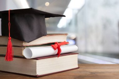 Mezuniyet şapkası, kitaplar ve diploma. 