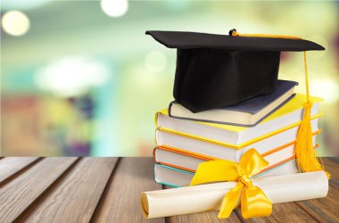 Mezuniyet şapkası, kitaplar ve diploma. 