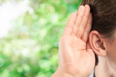 Kulağını ve bir şey dinlerken yakın işadamı elini tutar  